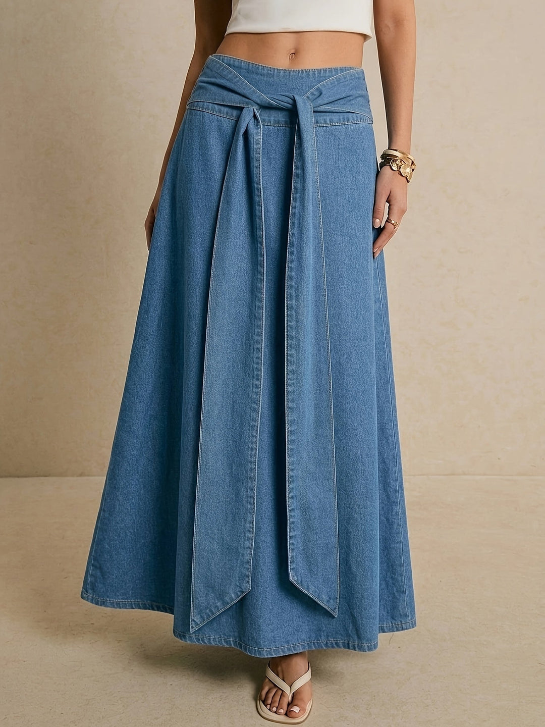 Women's blue denim maxi skirt featuring an adjustable tie waist, a versatile piece for casual wear.