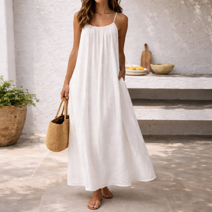 Flowy women's maxi dress with spaghetti straps, ideal for warm weather vacations & beach days.
