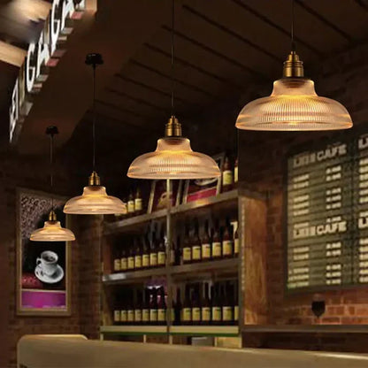 Modern transparent glass pendant light fixture providing warm light, ideal for contemporary interior design.