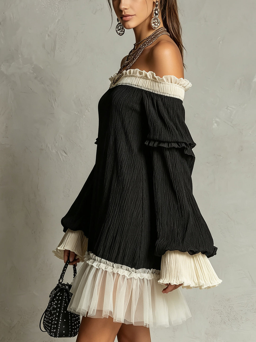Women's black off-shoulder mini dress with delicate ruffles and a flattering silhouette. Ideal for an elegant look.