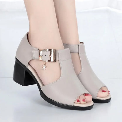 Close-up of the elegant buckle detail on black women's open-toe block heels.