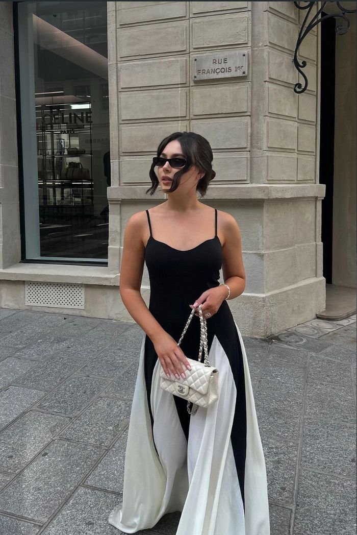 Detailed view of the elegant godet panels on a black & white contrast formal evening maxi dress.
