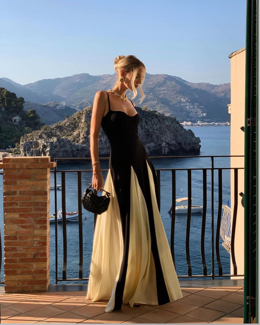 Luxurious fabric of a black & white contrast evening maxi wedding guest dress, elegant godet panel detail.