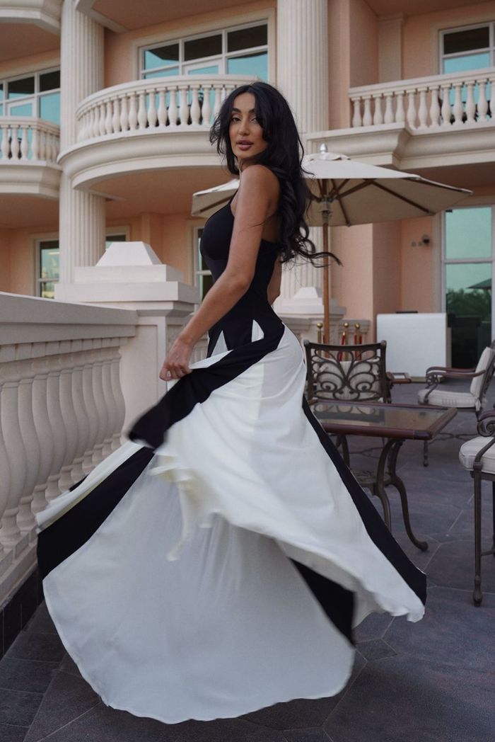 Flowing black & white contrast maxi wedding guest dress with godet panels, elegant movement for special events.