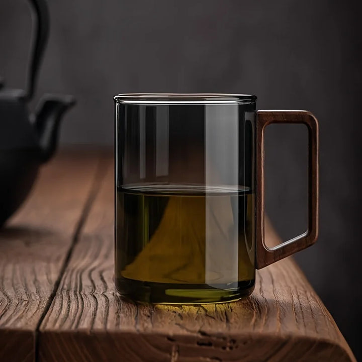 Clear glass coffee mug featuring a distinct walnut wood handle for a comfortable, stylish grip.