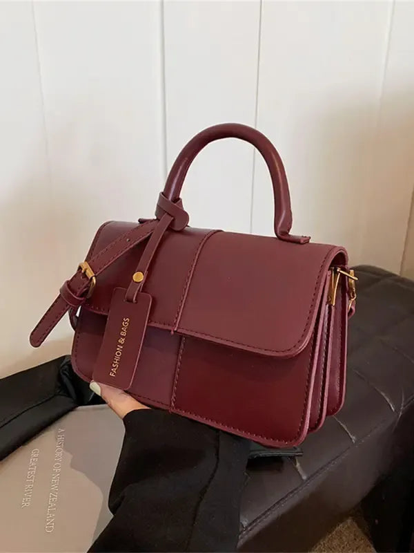 Versatile red structured shoulder bag, a chic women's handbag with a top handle for elegant styling.