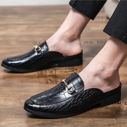 Black croc-embossed women's slip-on mules, featuring classic horsebit. Elegant, comfortable and sophisticated footwear.