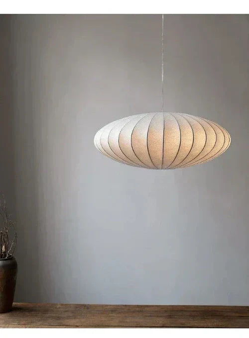 Close-up of a stylish ceiling light, showcasing its crystal elements & soft silk shade.