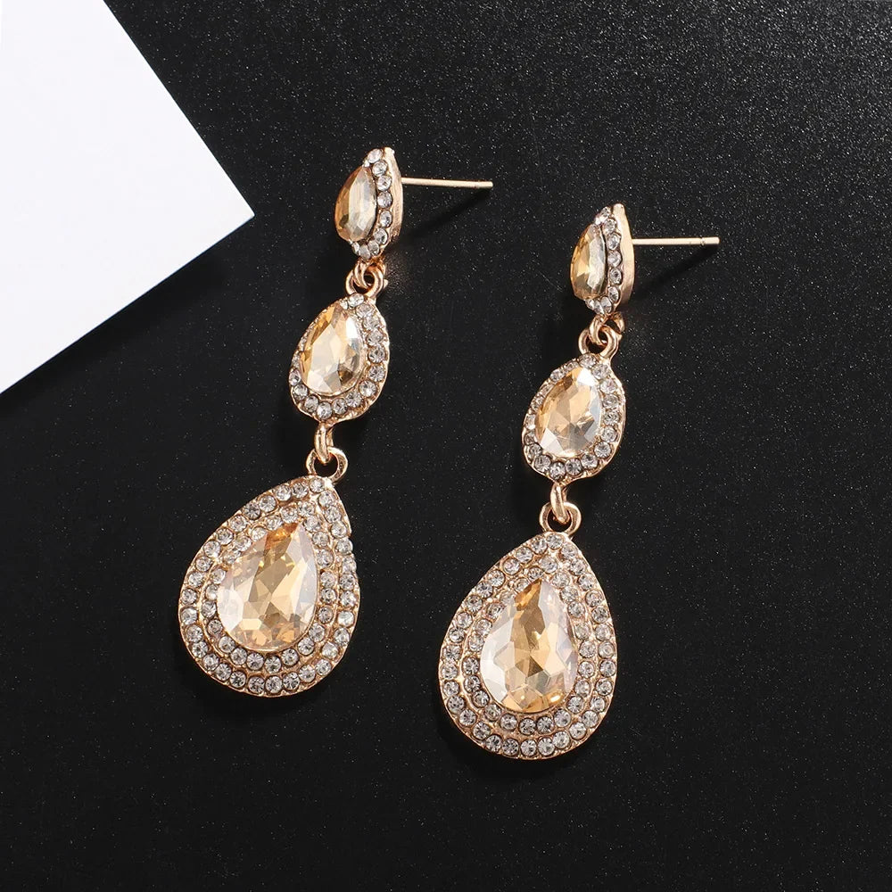 Shimmering women's emerald cascade drop earrings, elegant green stainless steel vibrant accessory.