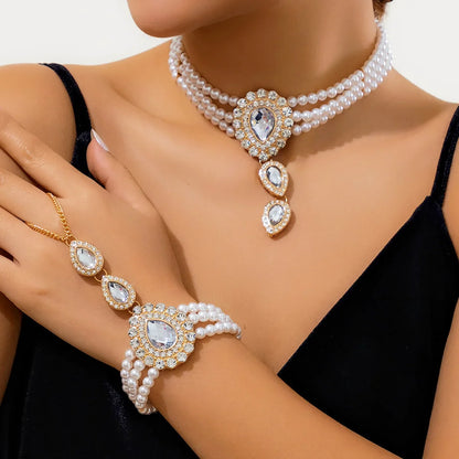 Women's gold jewelry set with elegant green peridot, white topaz, & pearl necklace and bracelet.