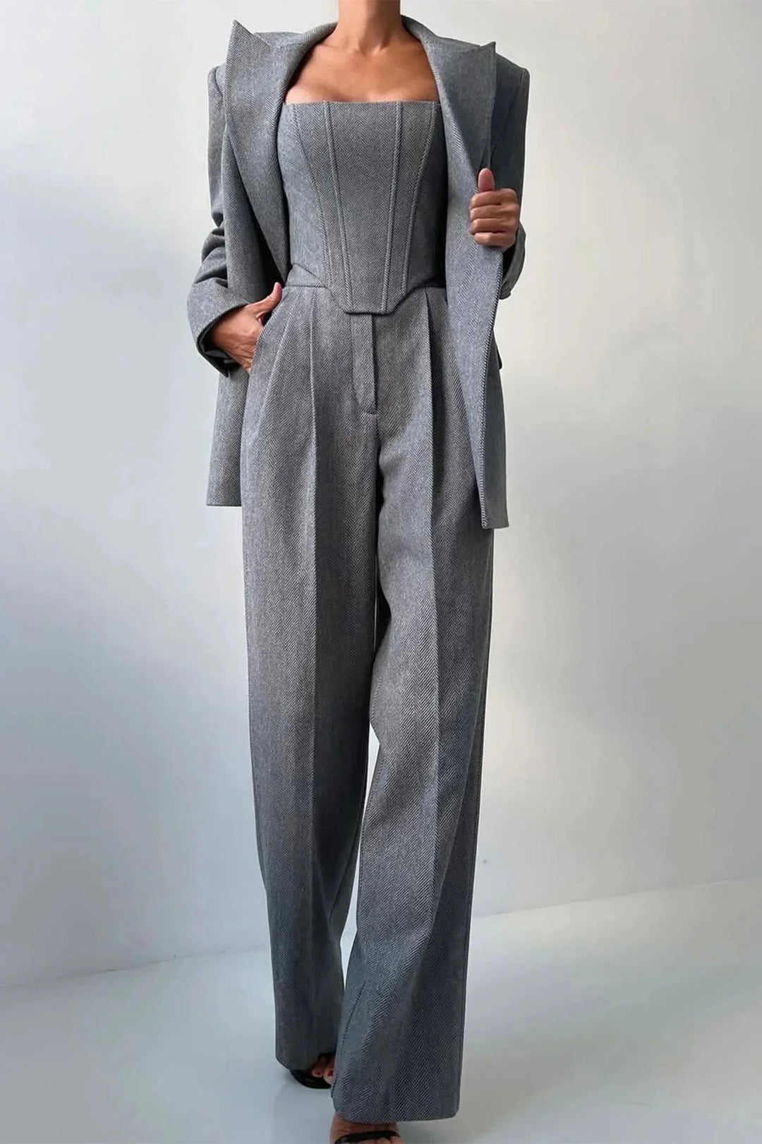 Pink business chic women's three-piece set: bustier, wide-leg pants, and blazer. Sophisticated.