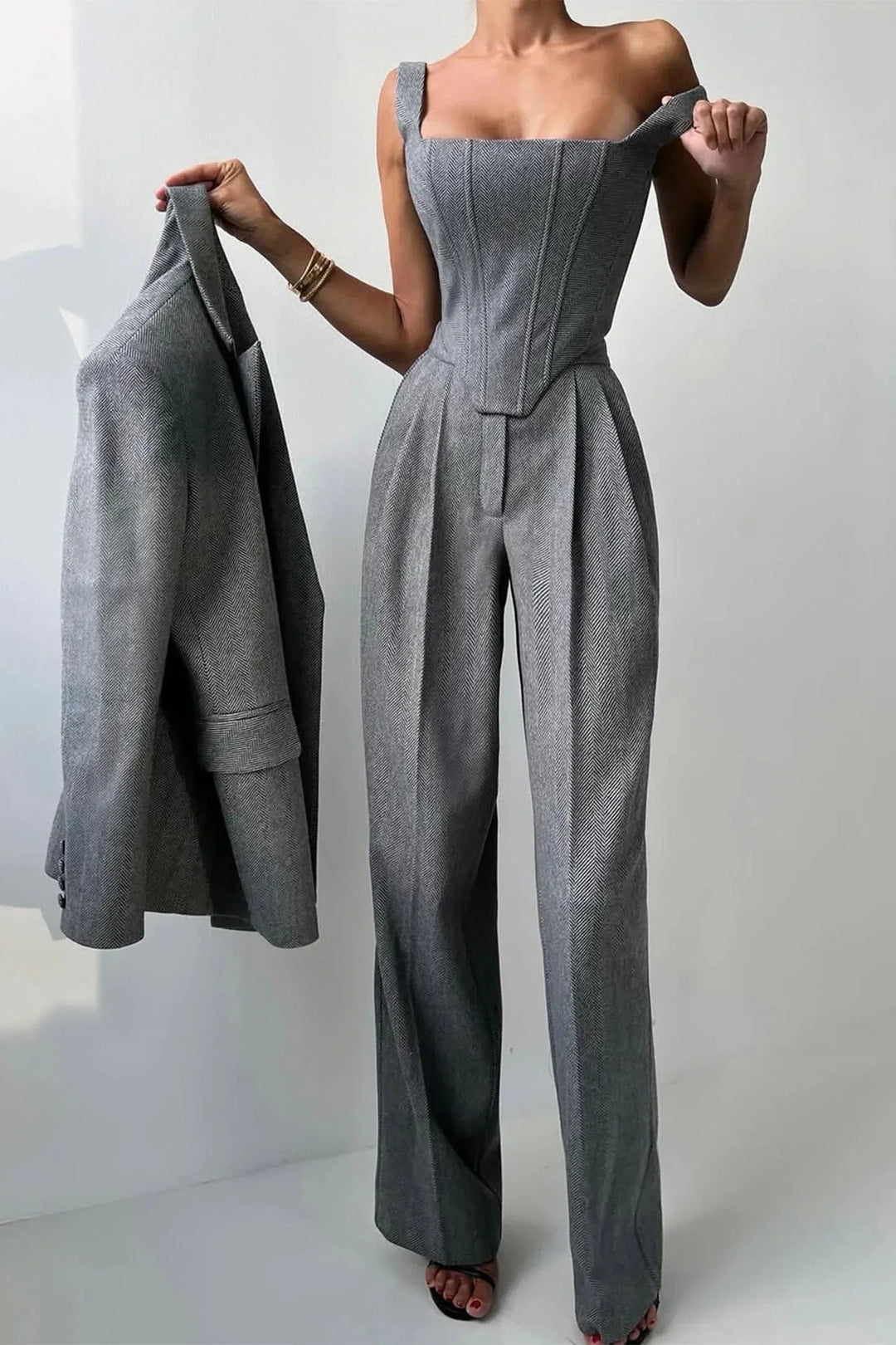 Stylish gray corset bustier top with wide-leg pants and oversized blazer, women's power suit.