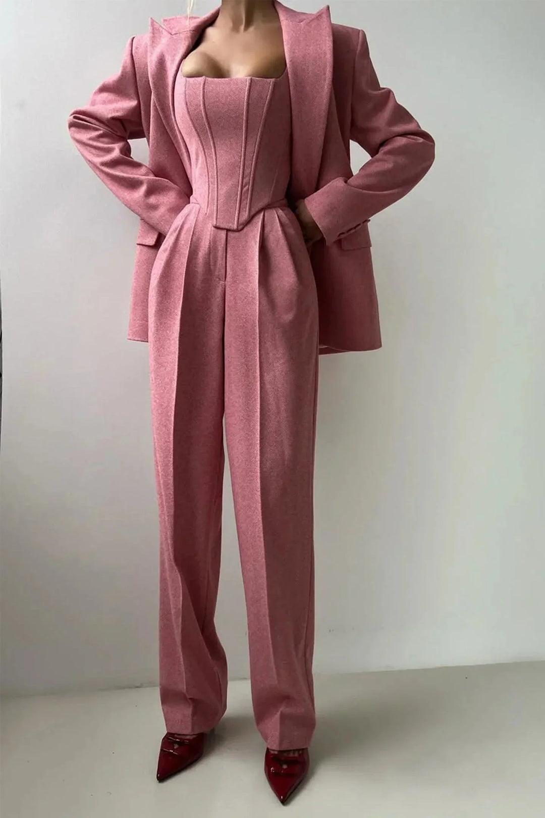 Pink sophisticated women's power suit featuring bustier, wide-leg trousers, and tailored blazer.