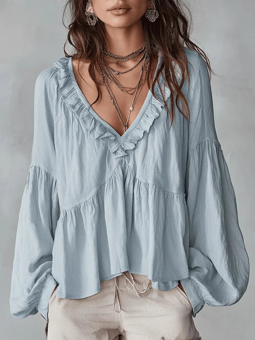 Sky blue relaxed fit V-neck ruffle blouse with long puff sleeves. Stylish casual or elegant top for summer.