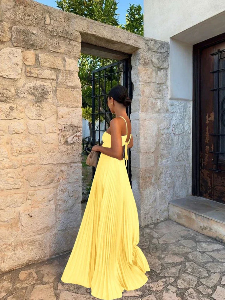 Women's pleated halter neck maxi wedding guest dress with flattering cut-out details and floor-length skirt.