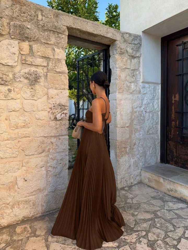 Chic pleated maxi dress for women, featuring a trendy halter neck, elegant cut-outs, and a flowing floor-length design.