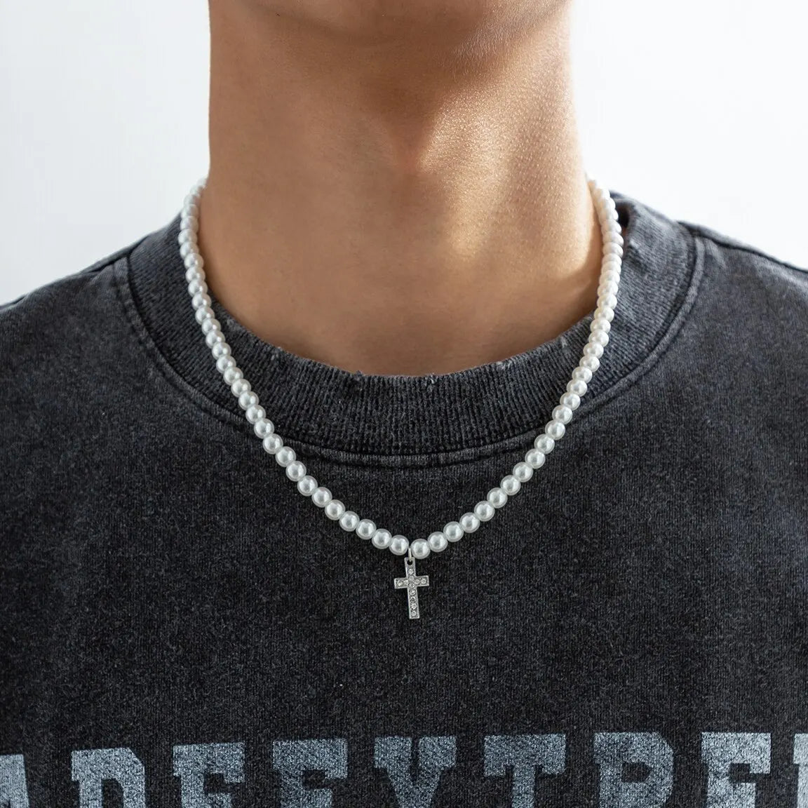 Elegant unisex pearl necklace with a delicate cross pendant, perfect for minimalist religious jewelry and fashion.