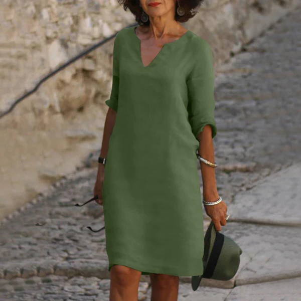 Women's elegant V-neck midi dress with three-quarter sleeves, beautifully styled for a chic spring look.