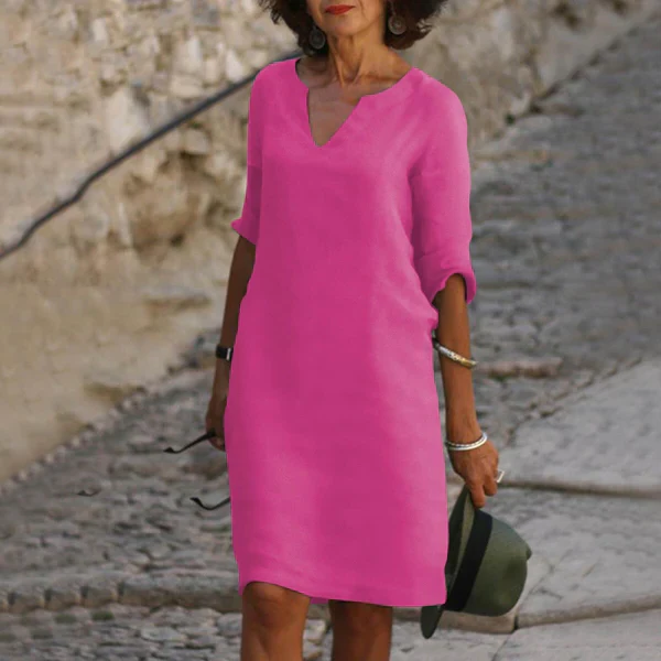 Woman in a flowy V-neck three-quarter sleeve midi dress, showing its elegant drape and comfortable fit.