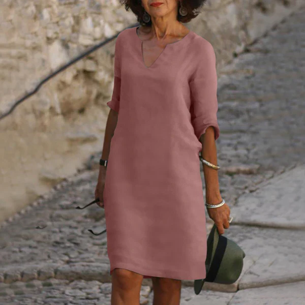 Detail of the elegant V-neckline & three-quarter sleeves of a women's comfortable flowy midi dress.
