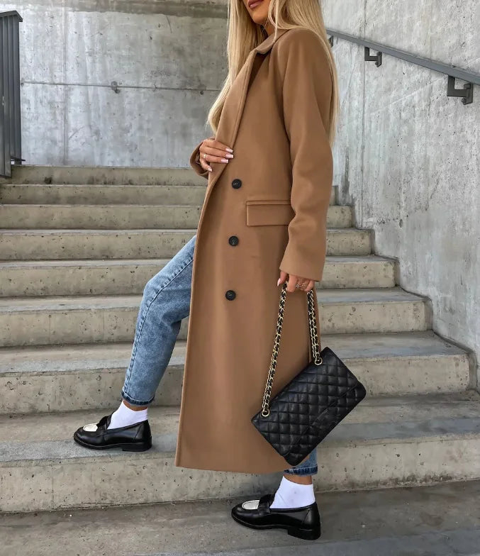 Beige women's elegant long trench coat with belt, versatile tailored outerwear for office and fall/winter fashion.