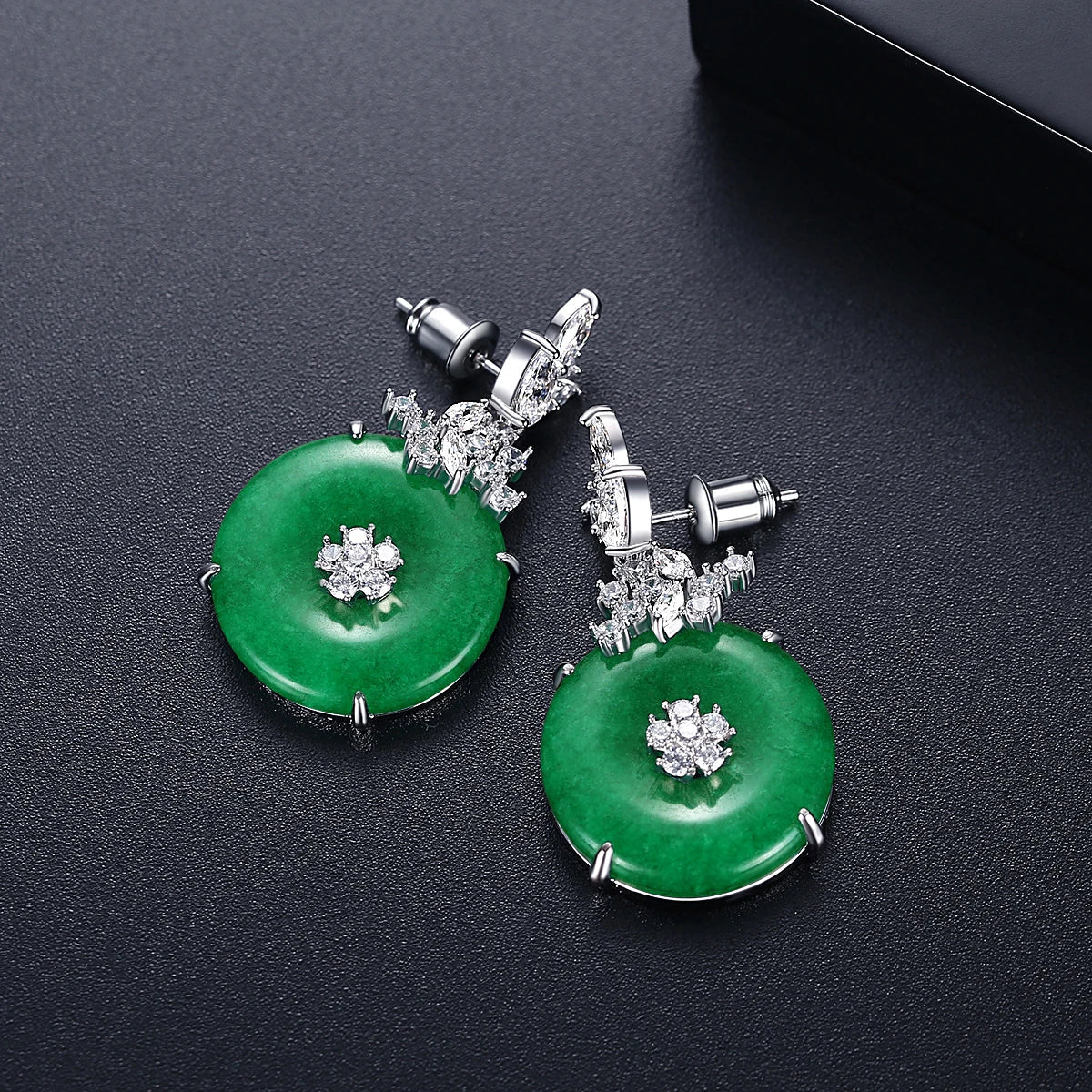 Stunning emerald green gemstone drop earrings for women, offering elegant luxury in a timeless fashion jewelry piece.