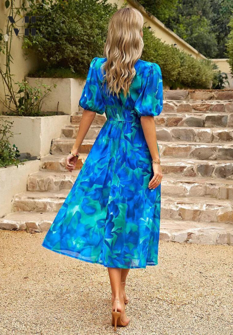 V-neckline and puff sleeves detail on elegant women's floral print midi dress. Feminine and chic spring fashion.