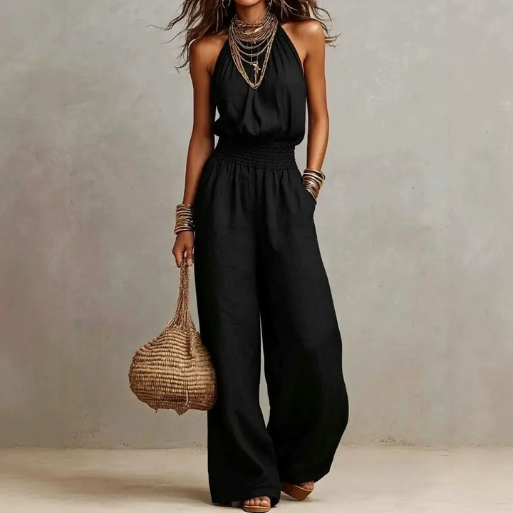 Back view of a women's elegant wide leg halter neck jumpsuit, showing its flowing silhouette and design.