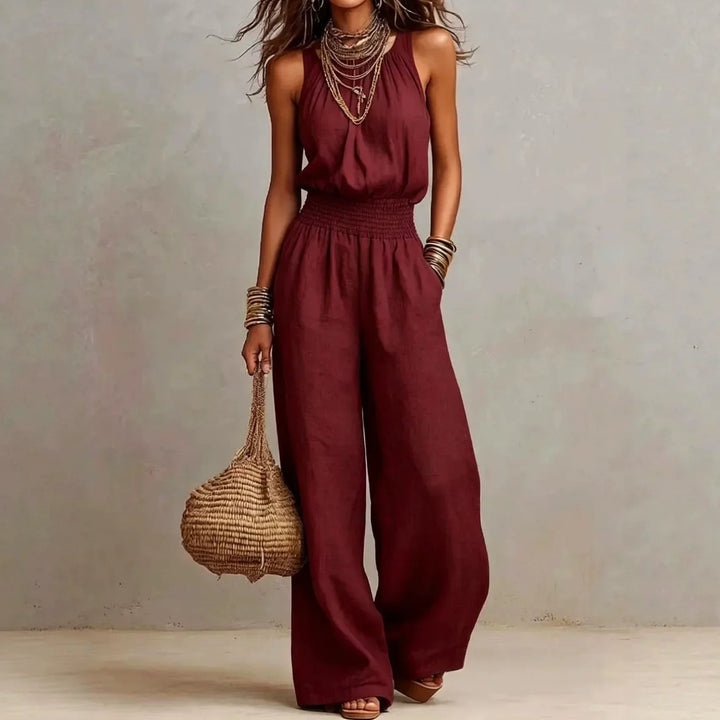 Woman wearing a chic flowing wide leg halter jumpsuit, perfect for a versatile and elegant summer resort look.