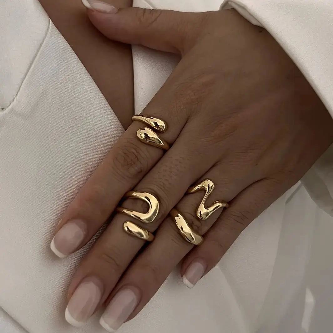 Elegant women's fluid sculptural ring set in gold, a modern fashion accessory.