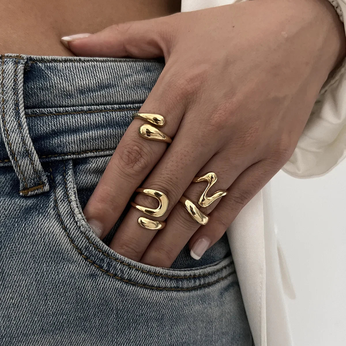 Modern women's fluid design ring set, a chic and elegant gold fashion accessory.