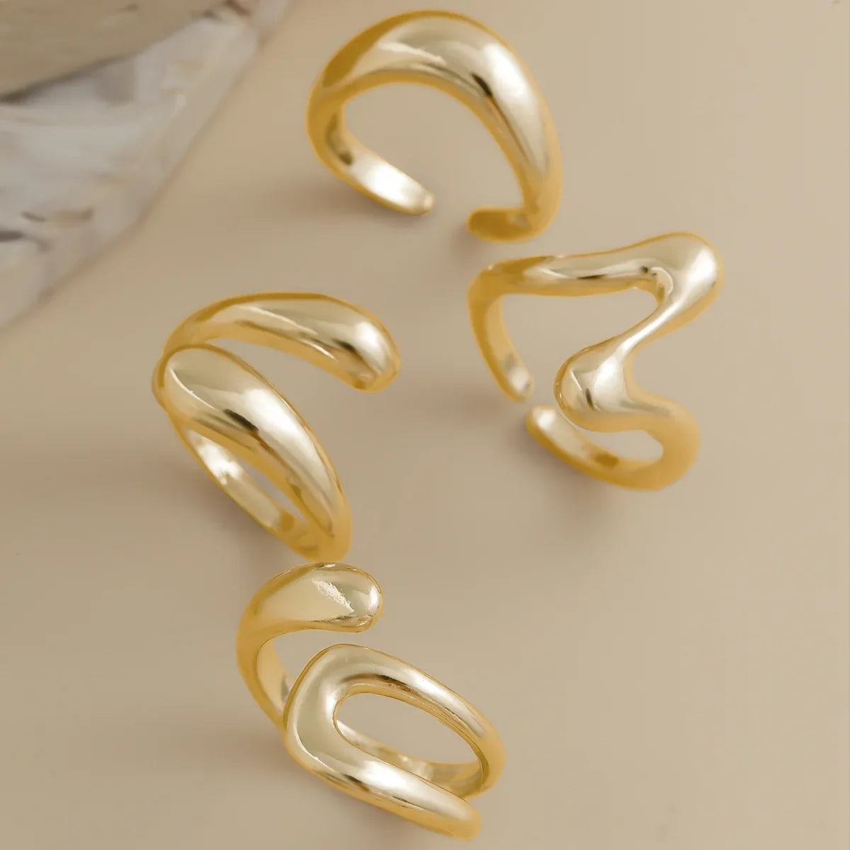 Stylish women's gold ring set with a fluid sculptural design, modern fashion jewelry.