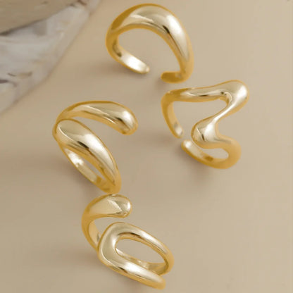 Stylish women's gold ring set with a fluid sculptural design, modern fashion jewelry.