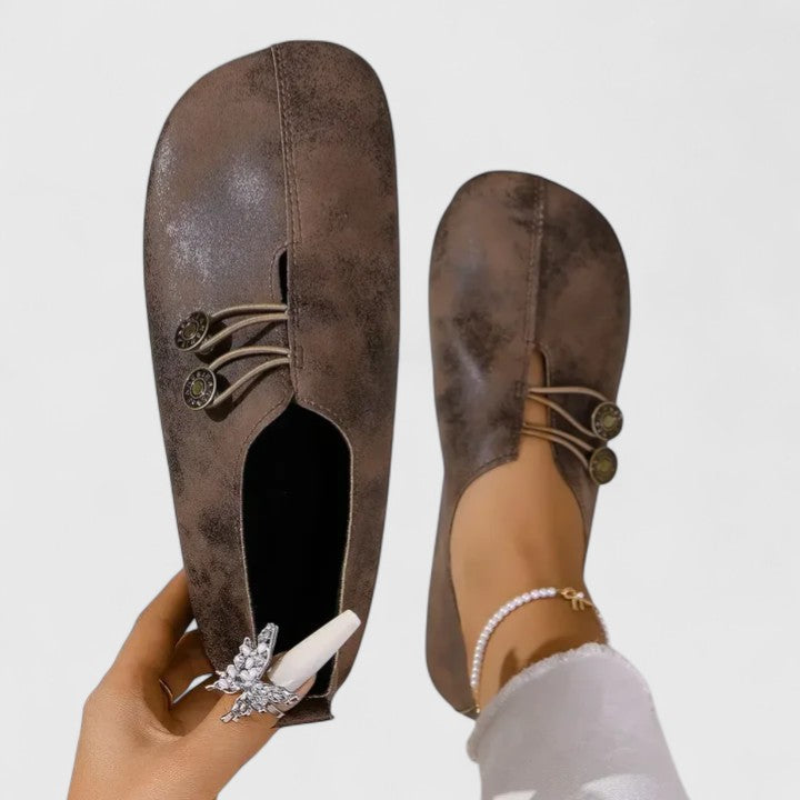 Detail shot: elastic button closure on women's elegant foldable loafers, emphasizing secure & stylish design.