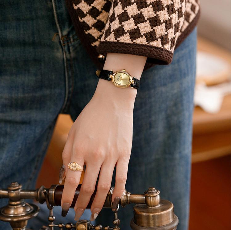 Versatile women's elegant watch, a gold-tone timepiece with a refined black dial and comfortable adjustable band.