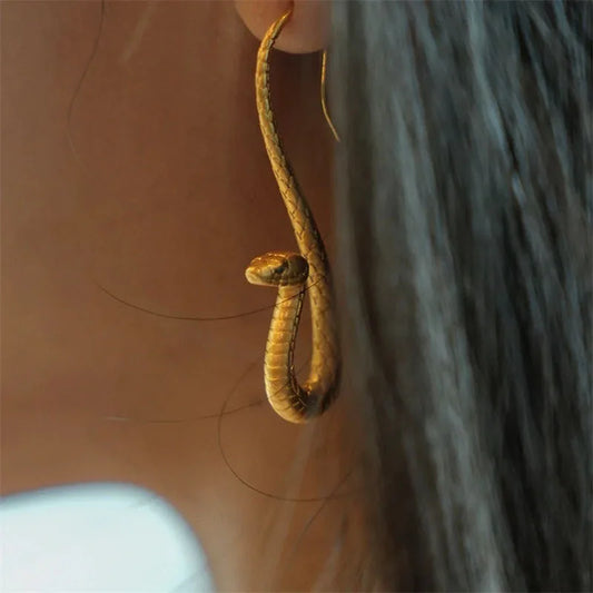 Elegant women's golden serpent dangle earrings, perfect statement jewelry for a unique fashion accessory.