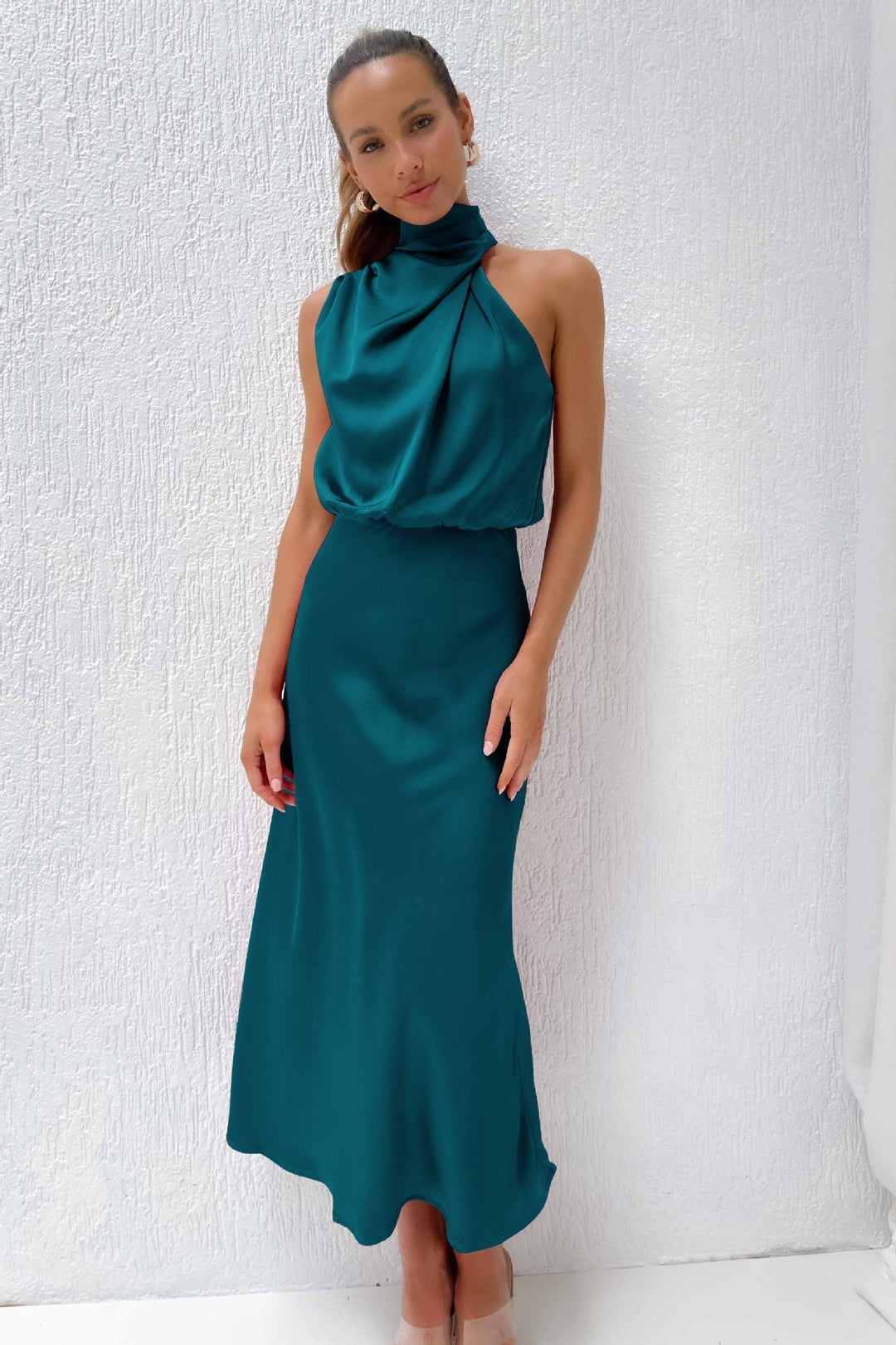 Full-length shot of a women's elegant halter evening gown, featuring a stylish open back.