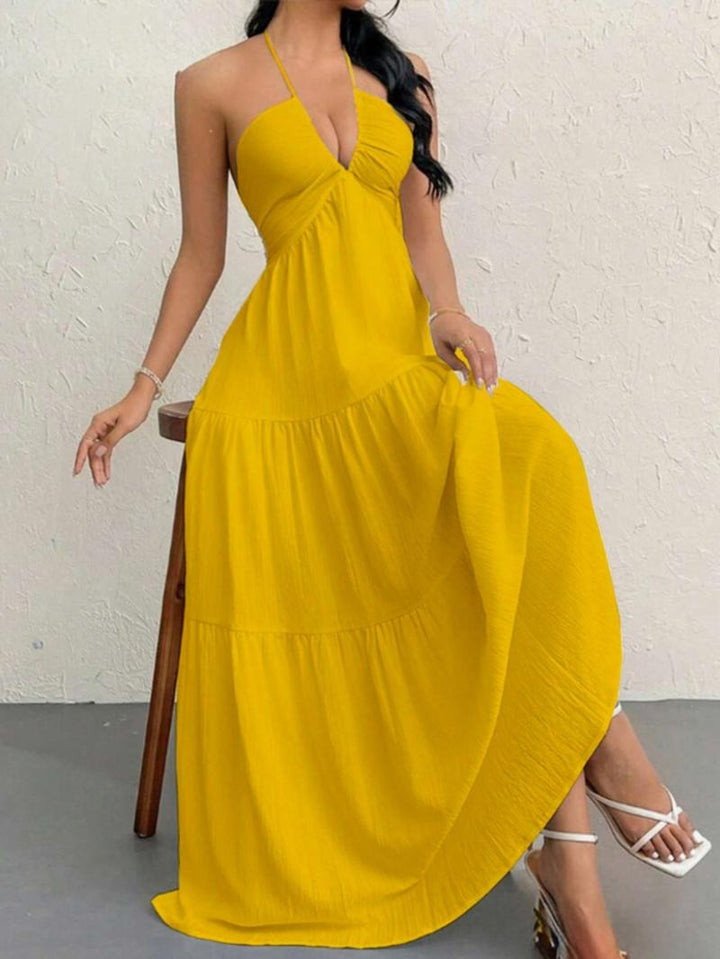 Confident women's long halter dress, elegant flowing maxi style. Ideal for special occasions & summer events.