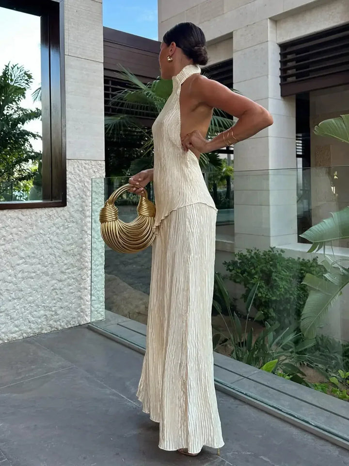 Stylish pleated two-piece matching set for women, featuring a halter neck crop top & comfortable wide-leg pants.