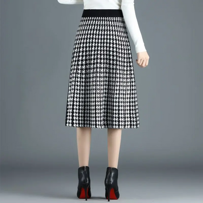 Versatile women's houndstooth midi skirt, elegantly pleated A-line style. High-waist chic apparel for work or fall fashion.