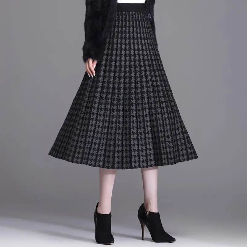 Chic women's elegant houndstooth midi skirt. Pleated A-line design, high-waist for sophisticated fall fashion.