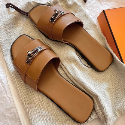 Chic women's leather square-toe sandals, designed as elegant slides with a stylish metallic buckle detail.