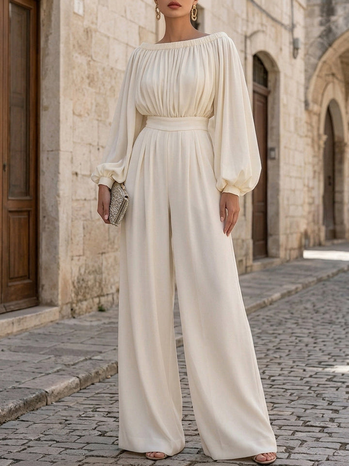 Women's elegant off-shoulder white maxi dress featuring graceful bishop sleeves & a long, flowing skirt.