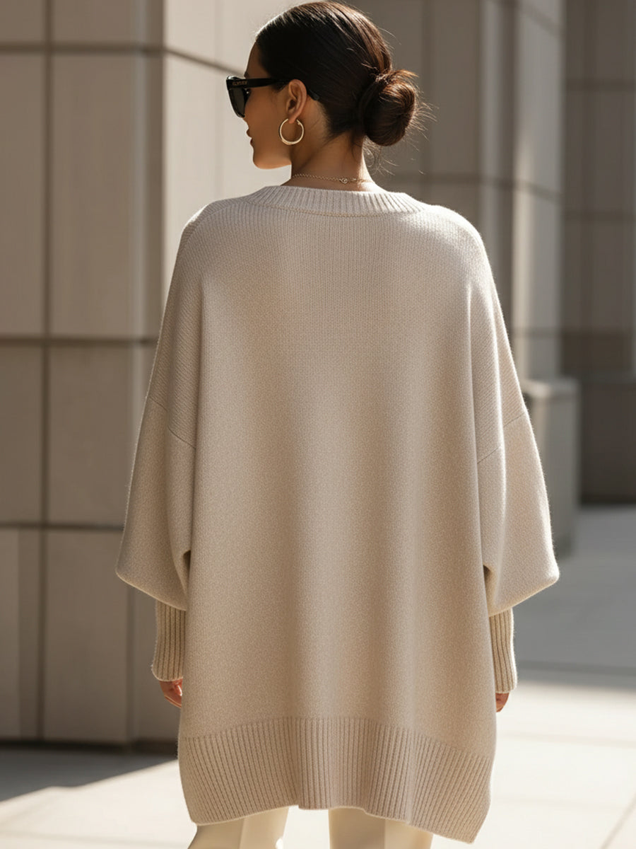 Fashionable women's elegant cape sweater. Oversized poncho style knit for autumn.