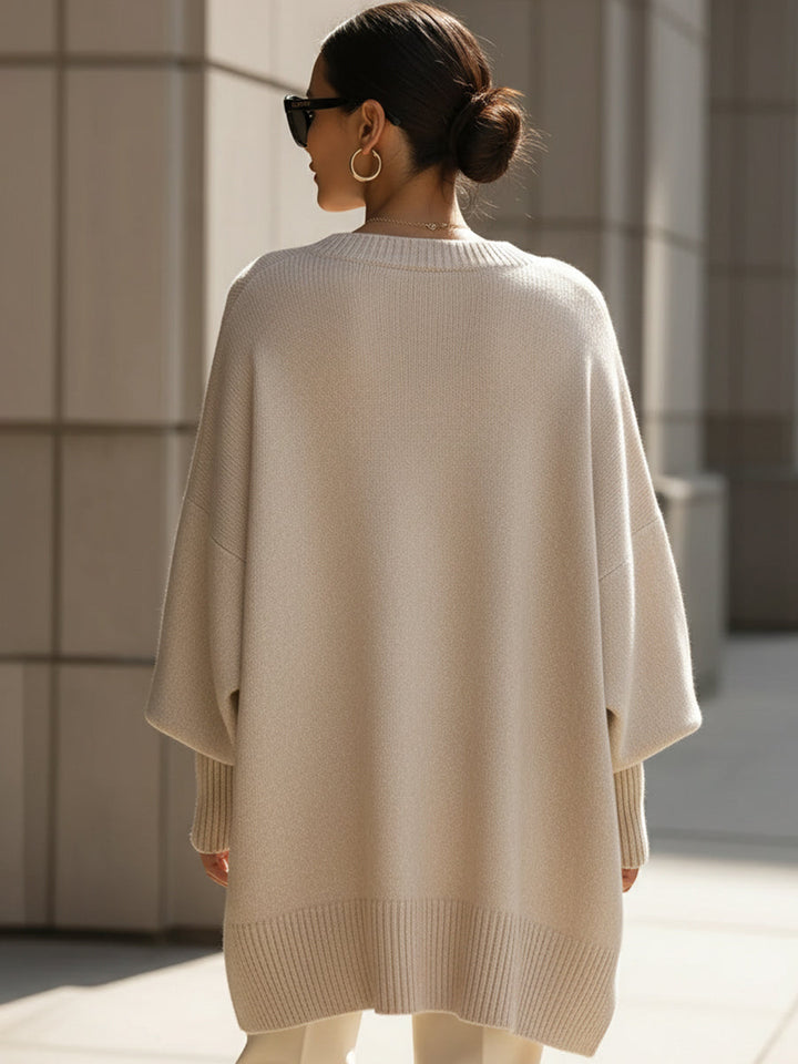 Fashionable women's elegant cape sweater. Oversized poncho style knit for autumn.