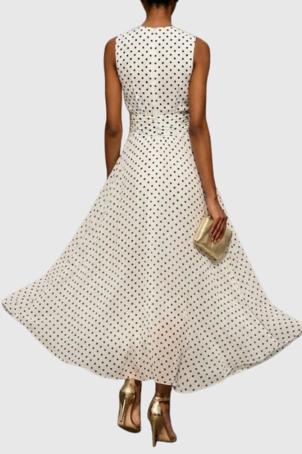 Rear view of a chic women's polka dot halter maxi dress with an elegant tie-back and flowing ruffle hem.