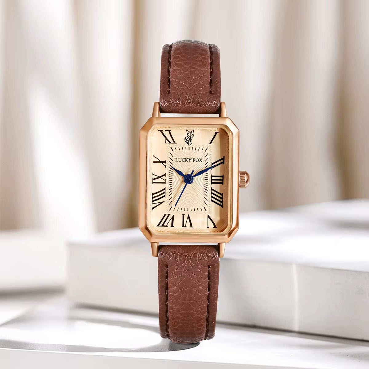 Classic women's gold-tone rectangle quartz watch with Roman numerals and black leather band.