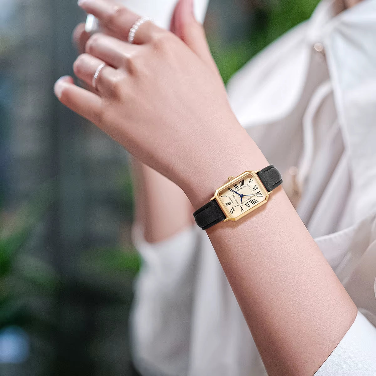 Elegant women's rectangle watch featuring gold-tone case, Roman numerals and a slim leather strap.