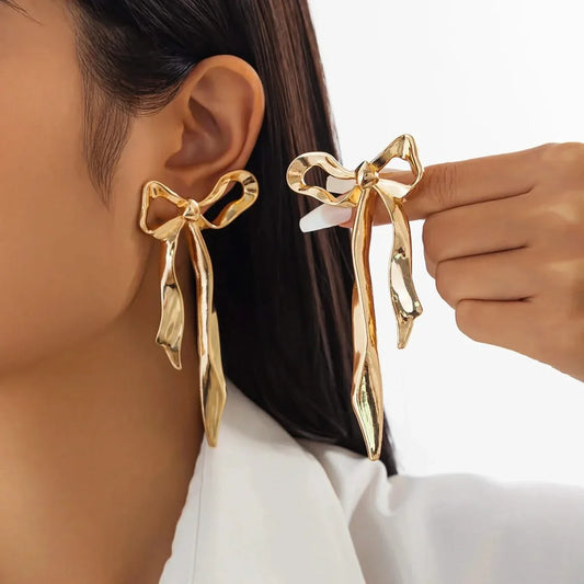 Elegant women's ribbon bow earrings. Dainty gold-plated bow design, perfect for everyday wear or special occasions.