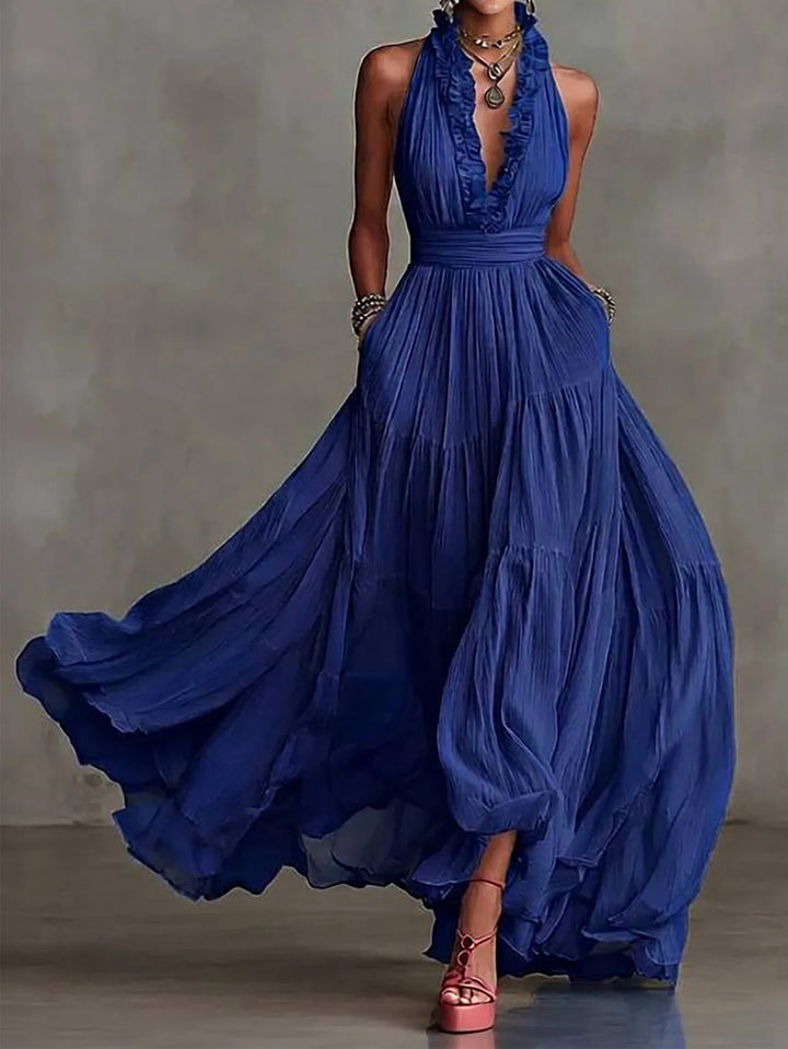 Sophisticated women's elegant maxi dress, backless with a deep plunging neckline & ruffle details. Wedding guest attire.